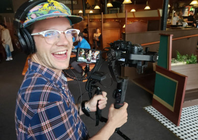 Man happily filming in a restaurant
