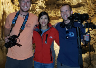 3 people standing in a cave
