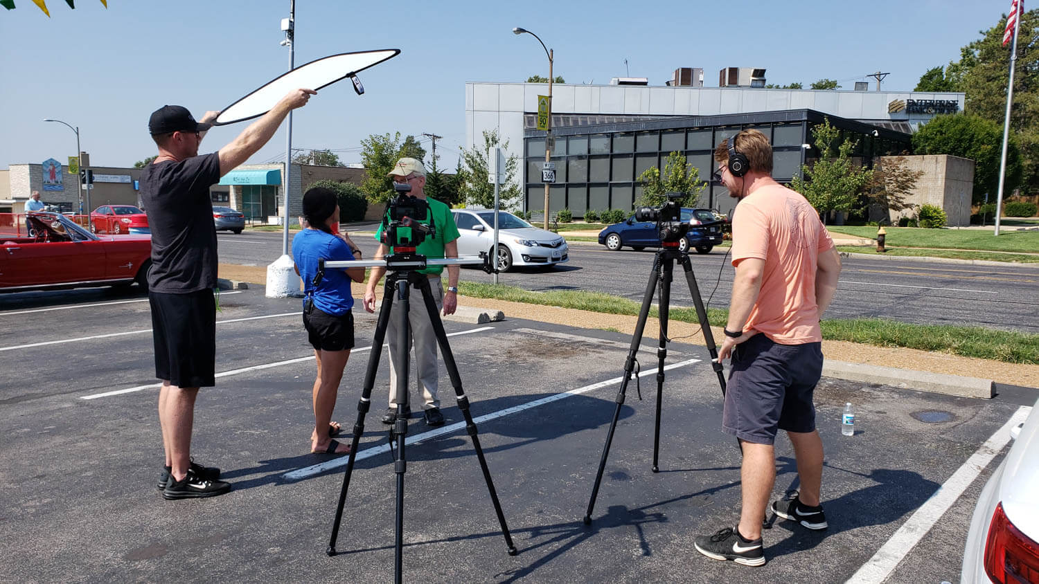people filming an interview in a parking lot