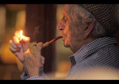 old man lighting a pipe